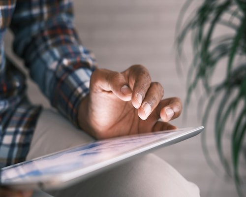 Close up of a hand adjusting brightness settings on a tablet device